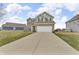 Inviting two-story home featuring a two-car garage, green siding and brick accents at 6180 N Rosewood Dr, McCordsville, IN 46055