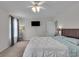 Bright main bedroom with a ceiling fan, bedside lamps, and neutral decor at 6180 N Rosewood Dr, McCordsville, IN 46055