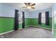 Carpeted bedroom with a ceiling fan, two windows with blinds, and a unique two-tone paint scheme at 633 Fletcher Ln, Beech Grove, IN 46107
