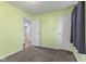 Bedroom featuring green walls, neutral carpeting, and multiple doorways at 633 Fletcher Ln, Beech Grove, IN 46107