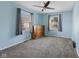 Blue bedroom with neutral carpeting, a wooden dresser, and windows with blinds at 633 Fletcher Ln, Beech Grove, IN 46107