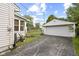 Detached garage with a paved driveway and chain link fence on a sunny day at 633 Fletcher Ln, Beech Grove, IN 46107
