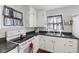 White kitchen showcasing updated appliances, white cabinetry, dark countertops, and a stainless steel sink at 633 Fletcher Ln, Beech Grove, IN 46107
