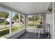 Enclosed porch with bright windows overlooking the neighborhood street view at 633 Fletcher Ln, Beech Grove, IN 46107