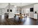 Open-concept dining area featuring hardwood floors, a modern light fixture, and access to the outdoor patio at 6545 Briarwood Pl, Zionsville, IN 46077