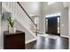 Inviting foyer with high ceilings, dark hardwood floors, staircase, and a front door that provides natural light at 6545 Briarwood Pl, Zionsville, IN 46077