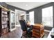 Well-lit home office with hardwood floors, a large desk, ample bookshelf space, and double doors at 6545 Briarwood Pl, Zionsville, IN 46077
