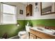Cozy bathroom with green wainscoting, patterned tile flooring and built in vanity at 741 Dequincy St, Indianapolis, IN 46201