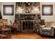 A close up of a stone fireplace with decor, windows with patterned glass, and wood floors at 741 Dequincy St, Indianapolis, IN 46201