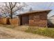 Side view of a detached garage featuring a brown garage door and partial wood fence at 741 Dequincy St, Indianapolis, IN 46201