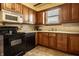 Traditional kitchen boasts wood cabinets, modern appliances, and a cozy, functional layout for cooking and entertaining at 741 Dequincy St, Indianapolis, IN 46201