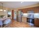 Eat-in kitchen with stainless appliances, wood cabinets, and natural light; transition to dining area at 7531 Bancaster Dr, Indianapolis, IN 46268