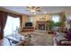 Living room with brick fireplace, large windows with sheer drapes, and a comfortable seating area at 7531 Bancaster Dr, Indianapolis, IN 46268