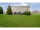 Spacious backyard featuring a well-kept lawn, a deck with a dining set, and mature trees at 8253 Belcrest Ct, Indianapolis, IN 46256