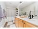 Bright bathroom featuring a double sink vanity, a large mirror, and a shower with a patterned curtain at 8253 Belcrest Ct, Indianapolis, IN 46256