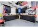 Organized garage with black cabinets, work benches, and various tools, perfect for projects and storage at 8253 Belcrest Ct, Indianapolis, IN 46256