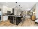 Modern kitchen with granite countertops, stainless steel appliances, island seating, and an adjacent living area at 8253 Belcrest Ct, Indianapolis, IN 46256