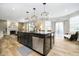 Open-concept kitchen island with granite countertops, barstool seating, and a sink, leading to a cozy living space at 8253 Belcrest Ct, Indianapolis, IN 46256