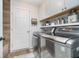 Well-lit laundry room with stainless steel washer and dryer, stylish accents and overhead cabinetry at 8253 Belcrest Ct, Indianapolis, IN 46256