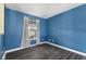 Bright bedroom with blue walls, wood-look flooring, and a window with natural light at 8551 Belle Union Ct, Camby, IN 46113