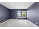 Bedroom with blue walls, neutral carpet, and a window showcasing the neighborhood at 8551 Belle Union Ct, Camby, IN 46113