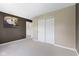 Bedroom featuring neutral carpet, brown accent wall with art, and white closet doors at 8551 Belle Union Ct, Camby, IN 46113