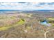 Panoramic aerial shot featuring multiple properties nestled within a lush, wooded setting and serene lakeside views at 8968 Old Haggard Rd, Morgantown, IN 46160
