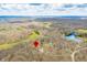 Stunning aerial image of a property location with a red pin drop, in a wooded area with a nearby lake at 8968 Old Haggard Rd, Morgantown, IN 46160