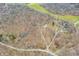 Scenic aerial view of a property with multiple buildings and a network of driveways amidst a dense forest landscape at 8968 Old Haggard Rd, Morgantown, IN 46160