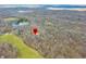 Aerial shot highlighting a location with a marker, nestled in a picturesque wooded area near a green field at 8968 Old Haggard Rd, Morgantown, IN 46160