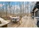 Wide angle of the back deck with wood railings and multiple seating areas among the bare trees at 8968 Old Haggard Rd, Morgantown, IN 46160