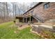 Exterior of brick home with spacious backyard, featuring a wooden deck and metal staircase at 8968 Old Haggard Rd, Morgantown, IN 46160