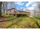 View of the backyard, deck, and lower level of the brick home with surrounding trees at 8968 Old Haggard Rd, Morgantown, IN 46160