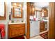 Functional bathroom area with wooden cabinetry, sink, mirror, and nearby laundry appliances at 8968 Old Haggard Rd, Morgantown, IN 46160