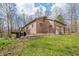 Brick house with a backyard deck viewed from the sloped lawn with mature trees at 8968 Old Haggard Rd, Morgantown, IN 46160