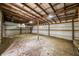 Spacious interior of outbuilding featuring metal walls, wood beams and a dirt floor at 8968 Old Haggard Rd, Morgantown, IN 46160