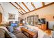 Spacious living room featuring a vaulted ceiling, wood beams, fireplace, and access to an outdoor patio at 8968 Old Haggard Rd, Morgantown, IN 46160