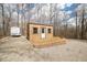 Tan outbuilding with white door on brick surround with trailer and gravel at 8968 Old Haggard Rd, Morgantown, IN 46160