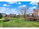 Scenic backyard view showcases lush green grass, mature trees, and a cozy deck for relaxation at 9253 Windrift Way, Zionsville, IN 46077
