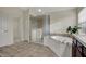 Well-lit bathroom features a soaking tub and shower with a view from the windows at 9253 Windrift Way, Zionsville, IN 46077