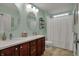 Well-lit bathroom featuring a double vanity, dual mirrors, and a shower with curtain at 9253 Windrift Way, Zionsville, IN 46077
