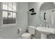 Bathroom features a pedestal sink and toilet with a window allowing for ample natural light at 9253 Windrift Way, Zionsville, IN 46077