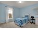 Bright bedroom featuring a bed with blue striped comforter, large window, and a desk with chair at 9253 Windrift Way, Zionsville, IN 46077