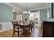 Charming dining room with hardwood floors, decorative lighting, and a window with white curtains at 9253 Windrift Way, Zionsville, IN 46077