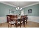 Formal dining room with hardwood floors, wainscoting, chandelier, and neutral paint colors at 9253 Windrift Way, Zionsville, IN 46077