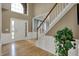 Spacious home foyer with hardwood flooring, a staircase, white trim, and a bright entry door at 9253 Windrift Way, Zionsville, IN 46077
