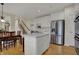 Bright kitchen features white cabinets, stainless steel refrigerator, and center island with white countertop at 9253 Windrift Way, Zionsville, IN 46077