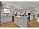Bright kitchen features white cabinets, an island with seating, stainless steel appliances, and hardwood floors at 9253 Windrift Way, Zionsville, IN 46077