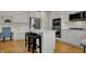 Well-lit kitchen features white cabinets, stainless steel appliances, island with seating, and hardwood floors at 9253 Windrift Way, Zionsville, IN 46077