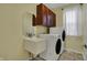 Laundry room with modern washer and dryer, sink, and upper cabinets for ample storage at 9253 Windrift Way, Zionsville, IN 46077